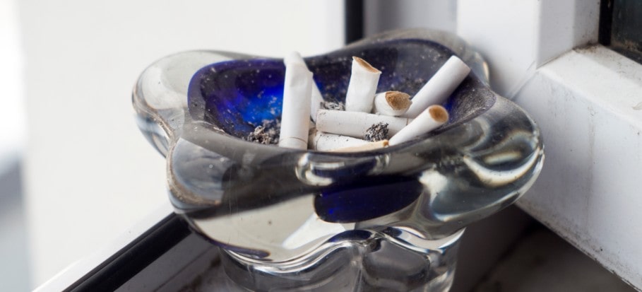 Ashtray with cigarettes on a window