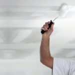 Professional painter in London working on a newly-plastered ceiling