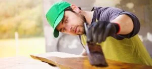 Professional painter working working on a varnished wood furniture