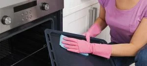 Woman cleaning oven tray