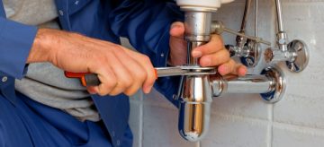 A plumber fixes a sink pipe amid the coronavirus breakdown