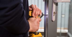 Professional locksmith is replacing a broken UPVC door lock mechanism