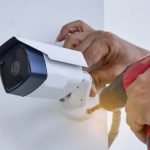 Professional CCTV expert is mounting a camera in a domestic property