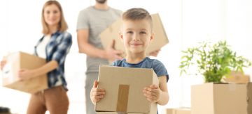 family carrying moving boxes