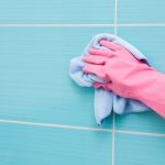hand cleaning bathroom tiles