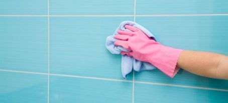 hand cleaning bathroom tiles