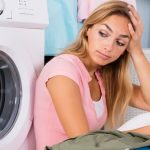 woman sitting next to washing machine