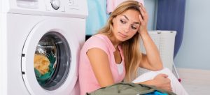woman sitting next to washing machine
