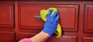 person cleaning wooden furniture