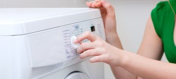 Person choosing settings on washing machine