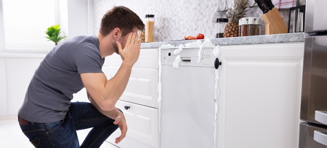 A man not knowing what to do with foaming dishwasher