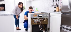 Technician repairing a dishwasher