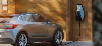 Electric car charging on a home charging point in front of house