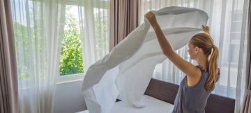 Young woman changing bed sheets