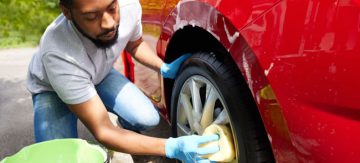 A men cleaning his alloy wheels close up
