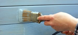 hand painting a fence