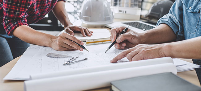 Close up of engineers working on blueprint of loft conversion