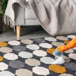 Woman cleaning rust stain on carpet