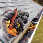 Man cleaning house gutters