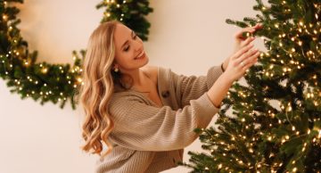 Woman decorating a big Christmas tree