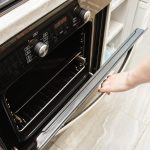 A woman opens the door of a modern catalytic oven