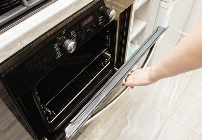 A woman opens the door of a modern catalytic
oven

