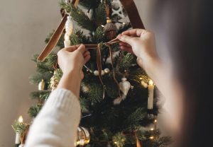 Woman decorating a Christmas tree with ribbons