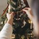 Woman decorating a Christmas tree with ribbons