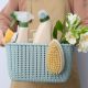 A woman carrying a basket with cleaning products prearing to spring clean