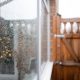 Water droplets on a large double glazing window on a conservatory during winter. A damp wooden side gate is visible.