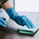 hands with rubber gloves sanitising table