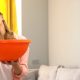 Upset woman calling roof repair service while water leaking from ceiling