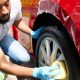 A men cleaning his alloy wheels close up