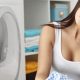 Woman sitting next to the washer, upset as the washing machine is not draining