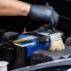 Close up on a man's hand cleaning engine bay with a brush